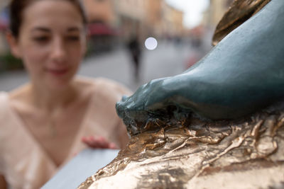 Close-up of woman by sculpture outdoors