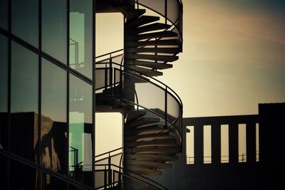 Low angle view of spiral staircase against sky during sunset
