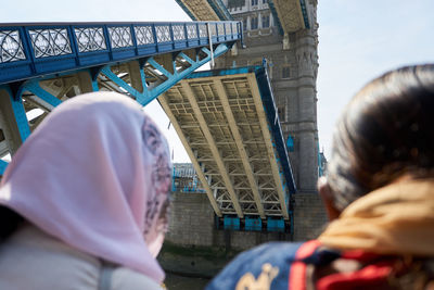 Rear view of people on bridge in city