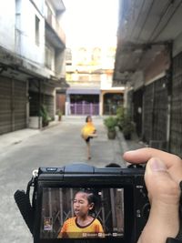 Reflection of man and woman on road in city