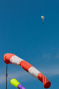 Low angle view of windsock against blue sky