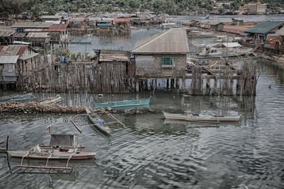High angle view of boats moored in river by buildings
