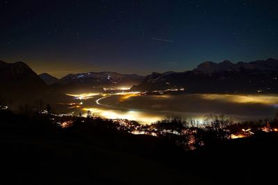 Illuminated mountains against sky at night