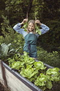 Full length of a smiling woman standing in farm