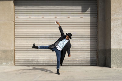 Full length of man with arms raised in city