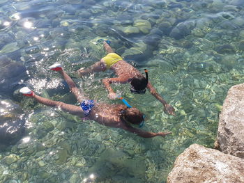 High angle view of siblings swimming in sea