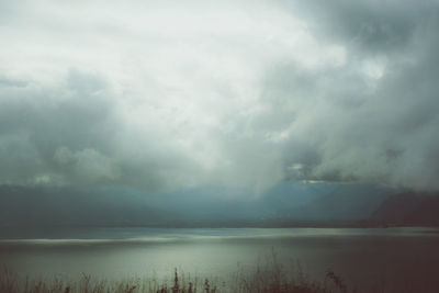Scenic view of lake against storm clouds