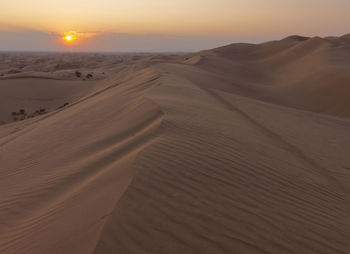 Scenic view of desert against sky during sunset