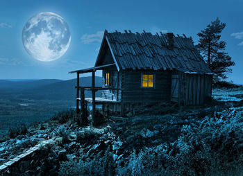 View of abandoned house on landscape against sky at night