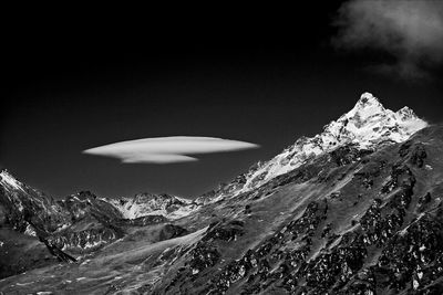 Scenic view of snowcapped mountains and lenticular clouds against sky