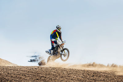 Man riding motorbike against sky