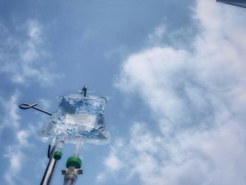 Low angle view of street light against cloudy sky