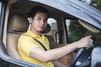 Portrait of young man sitting in car