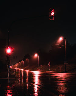 Illuminated light trails on wet street at night