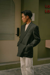 Young man standing against wall