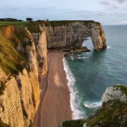 Scenic view of rock formation by sea against sky