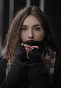 Portrait of beautiful young woman in warm clothing standing outdoors