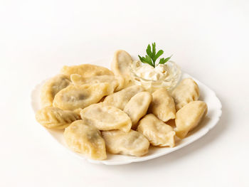 Close-up of served food in plate against white background