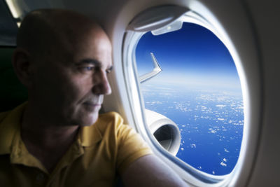 Senior man looking through airplane window
