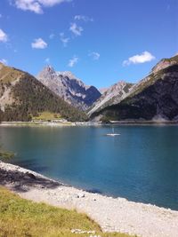 Scenic view of lake by mountains against sky