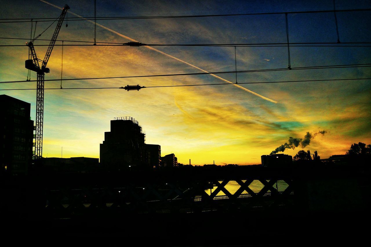 SILHOUETTE BUILDINGS IN CITY AGAINST SKY AT SUNSET