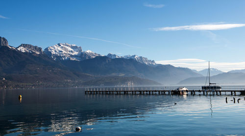 Scenic view of lake and mountains against blue sky