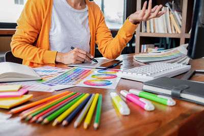 Midsection of creative businesswoman working at desk in office