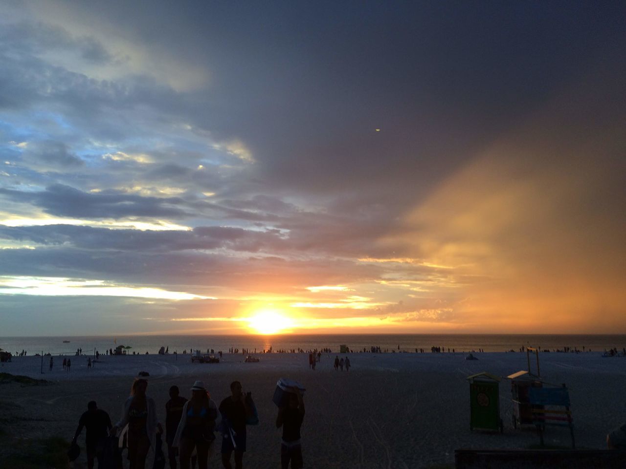 GROUP OF PEOPLE ON BEACH DURING SUNSET