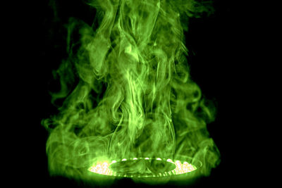 Close-up of illuminated lighting equipment against black background