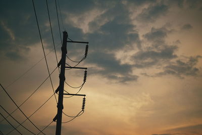 Low angle view of silhouette cables against sky