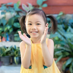 Positive charming 4 years old cute baby asian girl, little child with adorable pigtails hair smiling