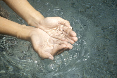 Cropped image of person holding water in hand