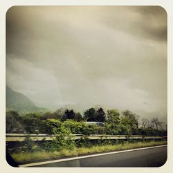 Scenic view of road against cloudy sky