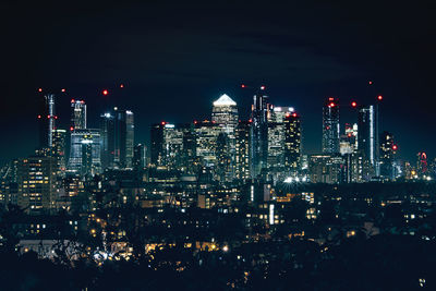 Illuminated buildings against sky at night