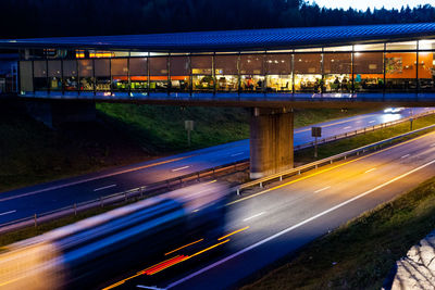 Illuminated marche holmestrand cafe over highway at dusk