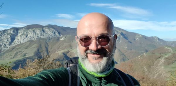 Portrait of smiling bald man against mountains