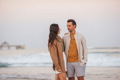 Young woman standing against sea