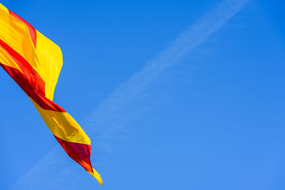 Low angle view of flag against blue sky