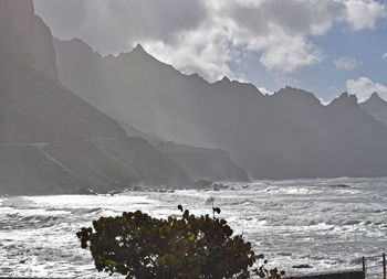 Scenic view of sea and mountains against sky