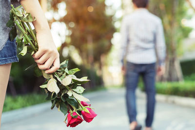 Midsection of woman holding flowering plant