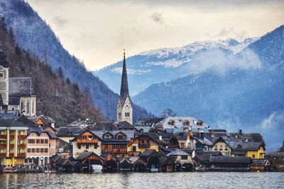 Panoramic view of building by mountains against sky, hallstatt lake.