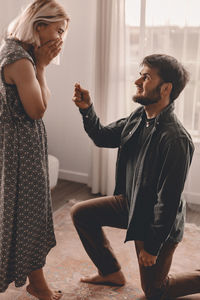 Side view of man and woman standing at home