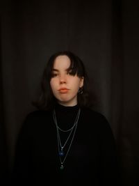 Portrait of teenage girl standing against backdrop