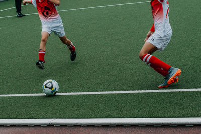 Low section of people playing soccer ball