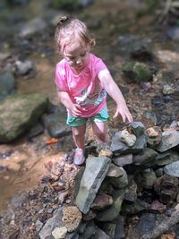 Cute girl standing on rock