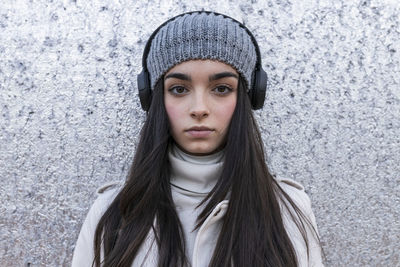 Portrait of woman wearing hat standing in snow