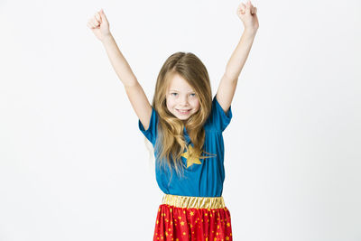 Portrait of smiling girl standing against white background