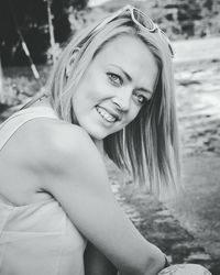 Portrait of happy young woman sitting at park