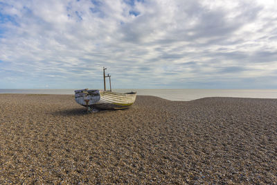 Scenic view of beach against cloudy sky