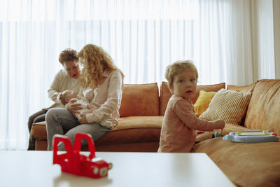 Portrait of smiling family sitting on sofa at home